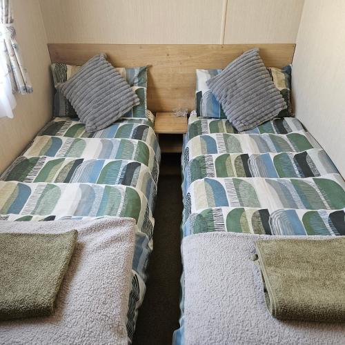 two beds sitting next to each other in a room at Thurston Manor Caravan Park, Pony Meadow in Dunbar