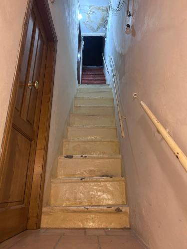 a stairway with a wooden door and a stair case at Borgo House in Abbadia San Salvatore