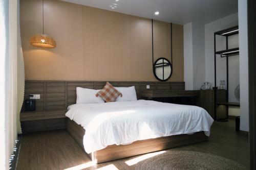 a bedroom with a large white bed and a mirror at Joie Homestay Huế in Thôn Trường Giang