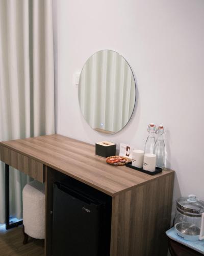 a mirror on top of a wooden table in a room at Joie Homestay Huế in Thôn Trường Giang