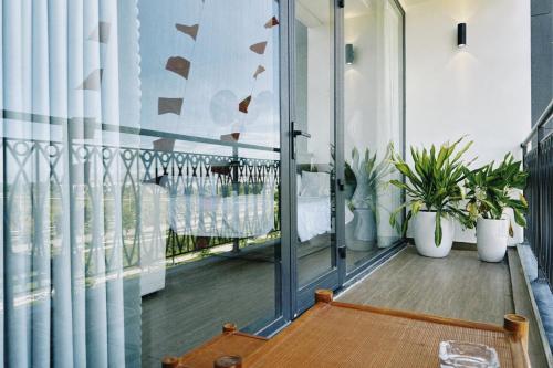 a balcony with potted plants and a table at Joie Homestay Huế in Thôn Trường Giang