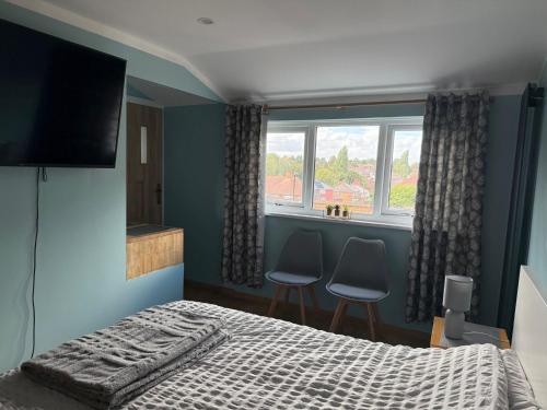 a bedroom with a bed and two chairs and a window at Studio- Sleeps 2- Free WiFi- Luxury Shower in Birmingham