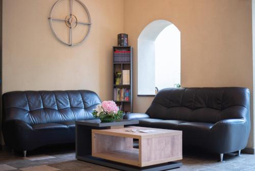 a living room with a leather couch and a coffee table at Hotel Marami in Sinaia