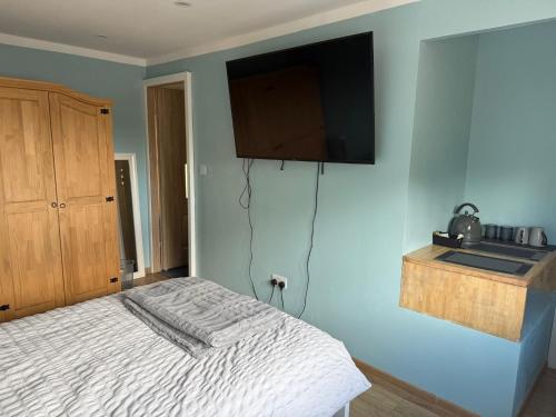 a bedroom with a bed with a television on the wall at Studio- Sleeps 2- Free WiFi- Luxury Shower in Birmingham