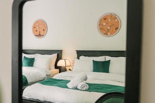a mirror reflection of a bedroom with two beds at Chez Lumi Hotel in Hanoi