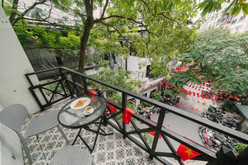 a table with a cup of coffee on a balcony at Chez Lumi Hotel in Hanoi