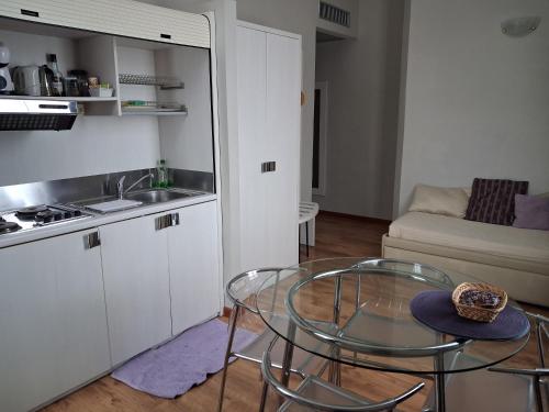 a small kitchen with a glass table and a sink at Lodges le Mura 2 in Florence