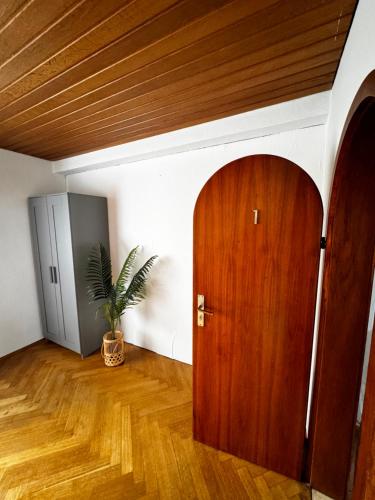a room with a wooden door and a potted plant at Vardi Haus in Ingolstadt