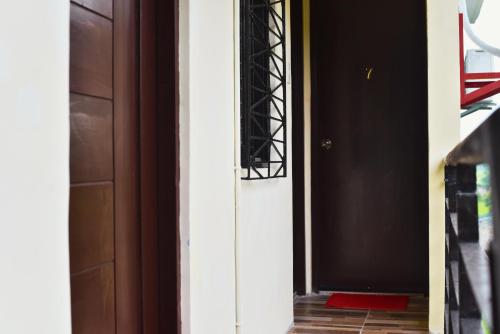 a hallway with a black door and a red rug at Point Vista Transient Accomodation in Daet