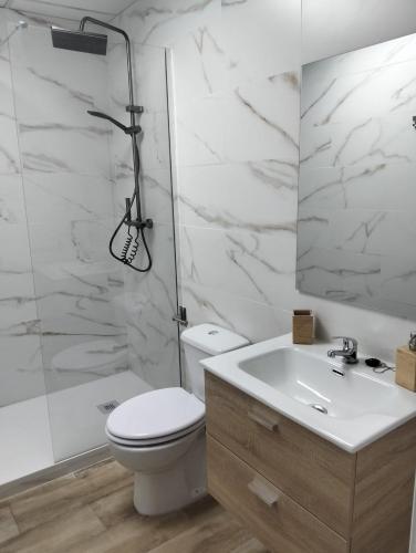 a bathroom with a toilet and a sink and a shower at Apartamentos vacacionales malba in Punta Umbría
