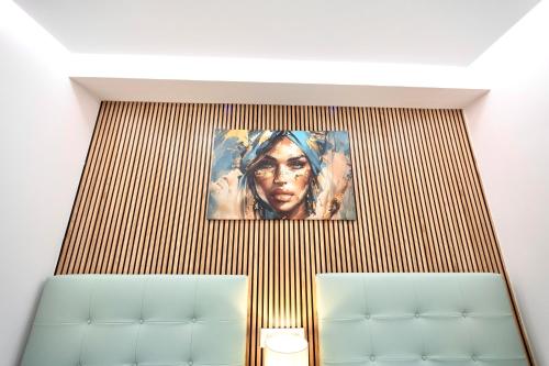 a painting of a woman hanging on a wall at Train Station by Lugo Collection in Lugo