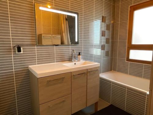 a bathroom with a sink and a bath tub at Le Canopée in Villefranche-sur-Saône