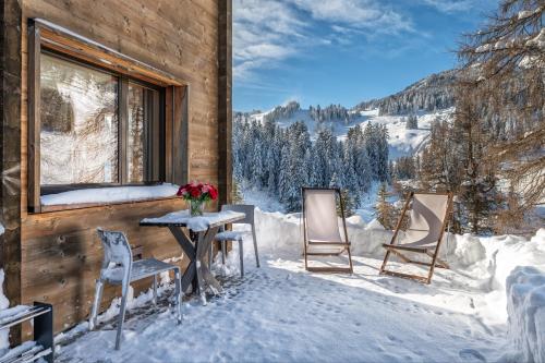 a patio with a table and chairs in the snow at Turrabuel in Parpan