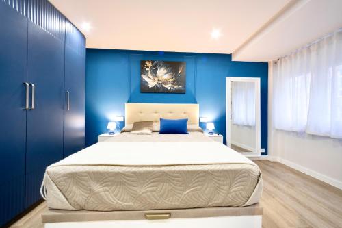 a bedroom with a large bed with blue walls at Train Station by Lugo Collection in Lugo