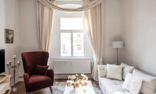 a living room with a white couch and a chair at Apartments Hoferhaus - Your Austrian Home in Bad Aussee