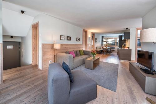 a living room with a couch and a television at Turrabuel in Parpan