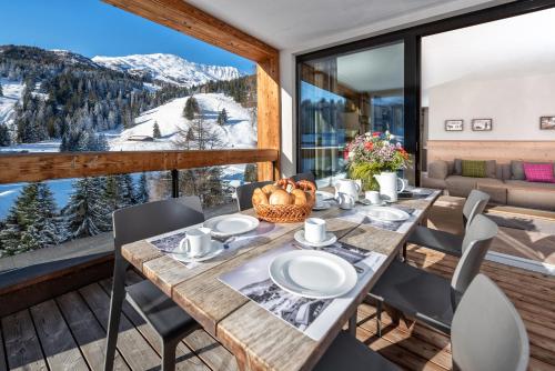 a table and chairs on a balcony with a mountain view at Turrabuel in Parpan