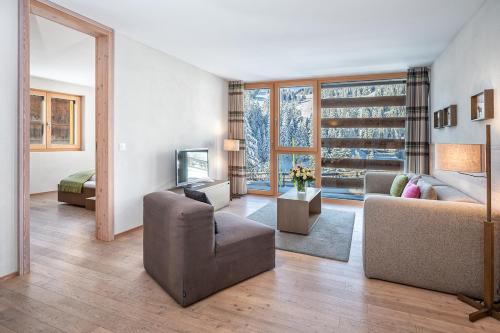 a large living room with a couch and a television at Turrabuel in Parpan