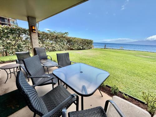 a patio with chairs and a table and the ocean at Papakea L101 · PK L101 Maui Ground-Floor Condo with Ocean Views in Honokowai