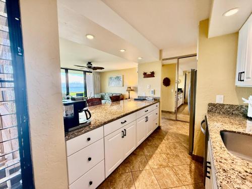 a large kitchen with white cabinets and a sink at Papakea L101 · PK L101 Maui Ground-Floor Condo with Ocean Views in Honokowai