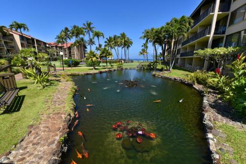 a pond in front of a building with kites in it at Papakea L101 · PK L101 Maui Ground-Floor Condo with Ocean Views in Honokowai