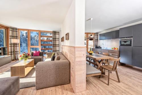 a kitchen and living room with a couch and a table at Turrabuel in Parpan