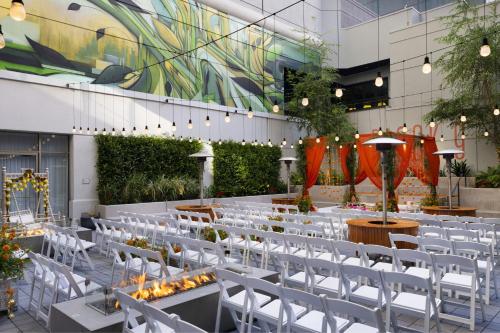 a banquet hall with white chairs and tables and a mural at The Clancy, Autograph Collection in San Francisco