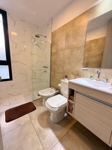 a bathroom with a toilet and a sink and a shower at Departamento premium con amplio patio en pleno centro de Carlos Paz in Villa Carlos Paz