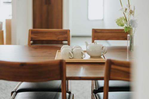 a wooden table with two tea sets on it at Four Seasons Home BY REINDEER in Biei