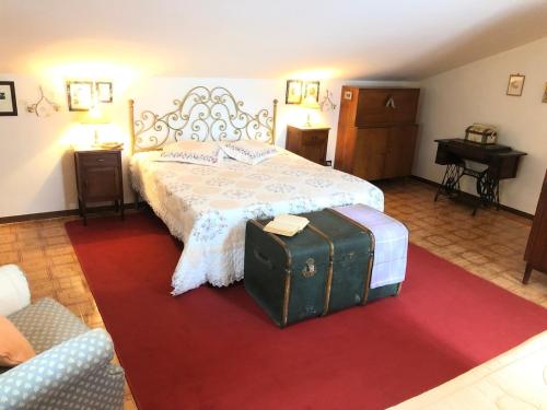 a bedroom with a bed with luggage on a red rug at Una casa ospitale con giardino in Castel SantʼAngelo