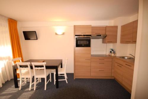 a kitchen with a table and chairs in a room at Résidence Marmottes - 2 Pièces pour 8 Personnes MAE-6013 in Gourette
