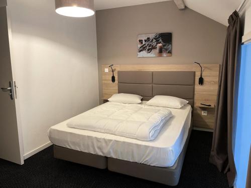 a bedroom with a bed with two white pillows at Résidence Le Portillo - Piscine - 2 Pièces pour 8 Personnes MAE-6133 in Gourette