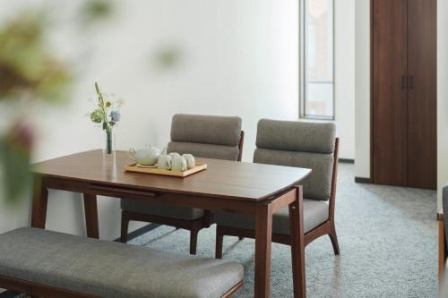 a dining room table with two chairs and a wooden table at Four Seasons Home BY REINDEER in Biei