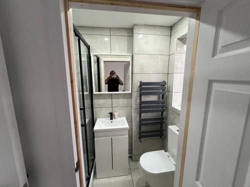 a person taking a picture of a bathroom mirror at Modern en-suite rooms Luton air port in Luton