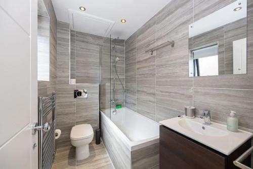 a bathroom with a sink and a toilet and a tub at Brooklyn Mews-Free Parking-Village Location in Cheadle