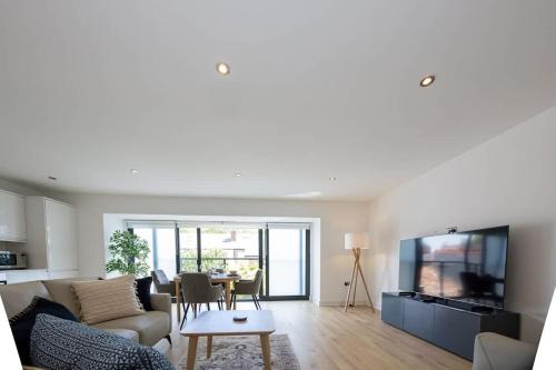 a living room with a couch and a tv and a table at Brooklyn Mews-Free Parking-Village Location in Cheadle