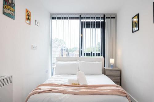 a bedroom with a bed with a large window at The Withington loft- Close To Uni's & Hospitals in Manchester