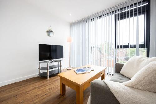 a living room with a couch and a table and a tv at The Withington loft- Close To Uni's & Hospitals in Manchester