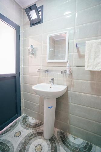 a bathroom with a sink and a mirror at Minimalist Fast Wifi &Ocean View in Tangier