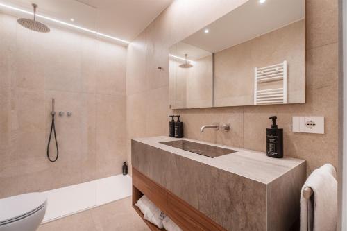 a bathroom with a sink and a toilet and a tub at Du Lac Et Du Parc Grand Resort in Riva del Garda