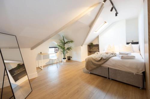 ein weißes Schlafzimmer mit einem Bett und einem Schreibtisch in der Unterkunft The Withington in Manchester