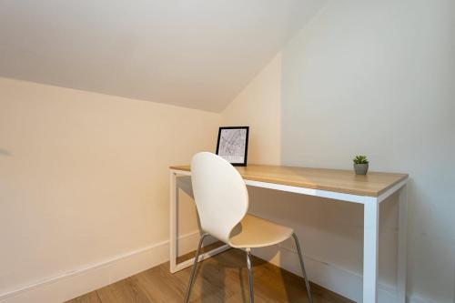 a white chair sitting next to a desk in a room at The Withington in Manchester