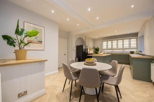 a kitchen and dining room with a table and chairs at The Coach House - Grade 2 Listed in Hale