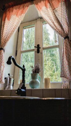 a kitchen counter with a sink and a window at Cifrovaná drevenička in Detva