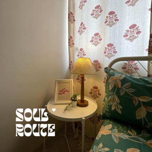 a table with a lamp and a picture on it next to a chair at Soul Route in Bhubaneshwar