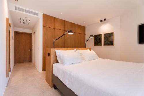 a bedroom with a large white bed and a television at Du Lac Et Du Parc Grand Resort in Riva del Garda