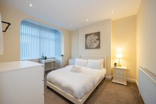 a bedroom with a white bed and a window at Windmill House in Manchester