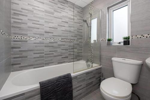 a bathroom with a toilet and a tub and a sink at Windmill House in Manchester