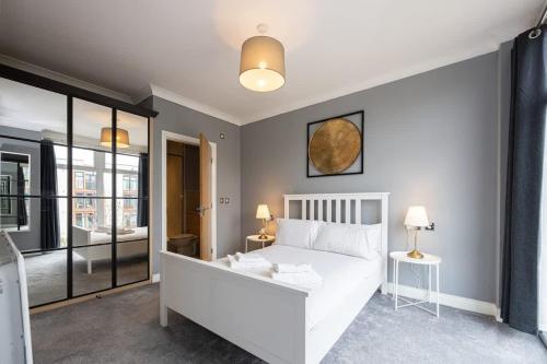a bedroom with a white bed in a room at The Sharston - Free Parking & Close To Airport in Wythenshawe