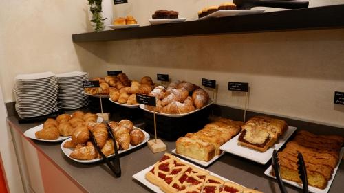 Un buffet con diversos pasteles, panes y tartas. en Hotel Venezuela, en Lido di Jesolo
